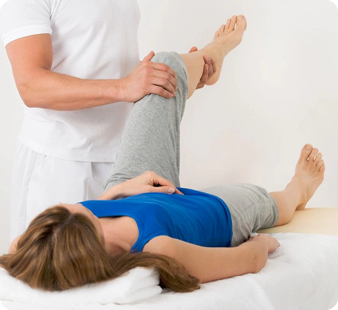 A person is stretching another person 's leg.